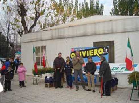  Giorno 3 dicembre 2006: gara podistica dedicata alla memoria di Laura e Sante Facchini. Nella foto, prima della premiazione, discorso preliminare di saluto. Si riconoscono da sinistra: figlio e nipote di Sante Facchini, il Capogruppo dei podisti, il Presidente del DLF Rimini, l'ex Capogruppo dei podisti e il Presidente provinciale CONI. 